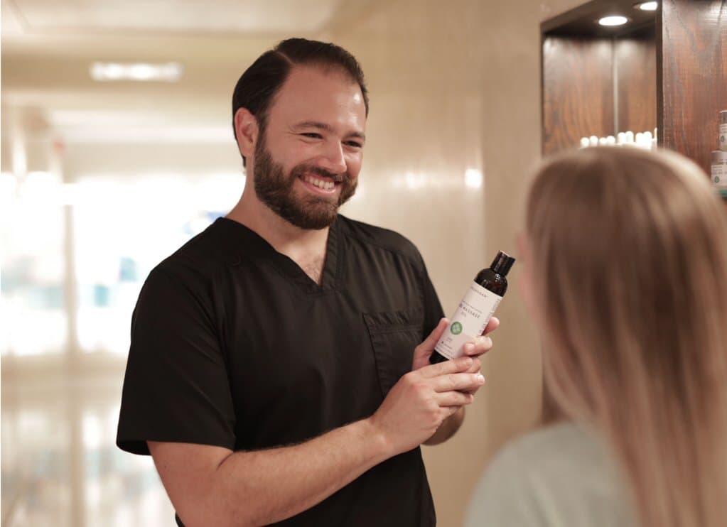 White Orchid Spa staff member showing customer a product