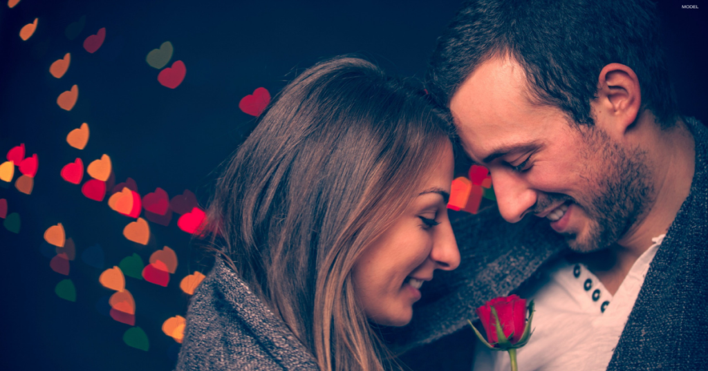 Woman and man touch their foreheads together, smiling (MODELS).