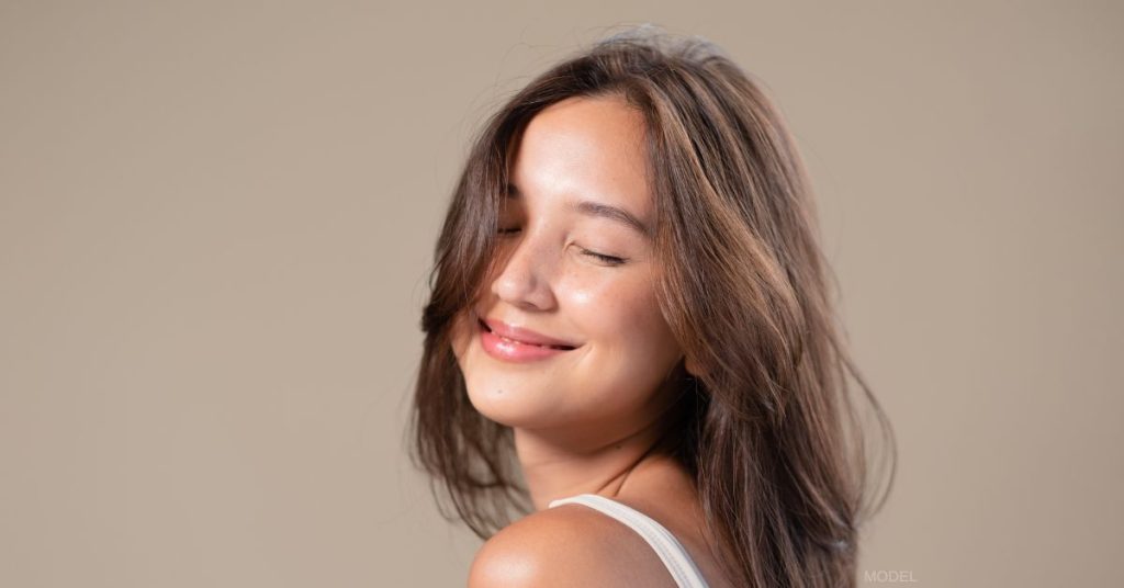 Woman with beautiful skin smiling with her eyes closed (model)