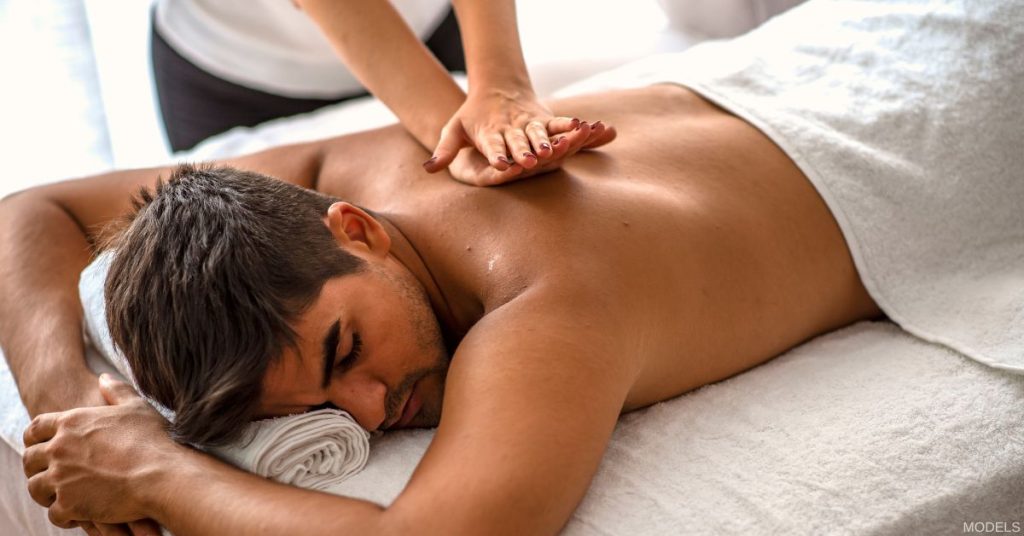 Man laying on treatment table getting a massage (model)