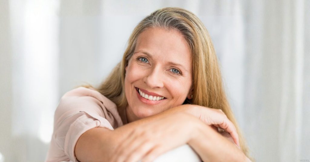 Woman smiling after BioTe® hormone therapy. (Model)
